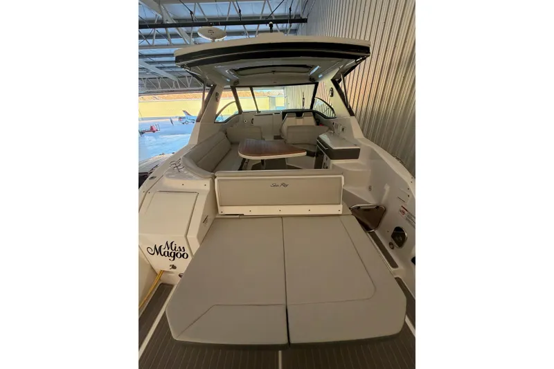Slide: The Image of 2023 Sea Ray Sundancer 320 Coupe interior with seating and table in a marina setting. - 10