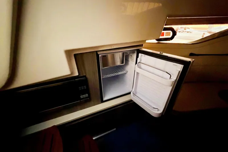 Slide: The Image of 2023 Sea Ray Sundancer 320 Coupe interior with open mini fridge. - 18