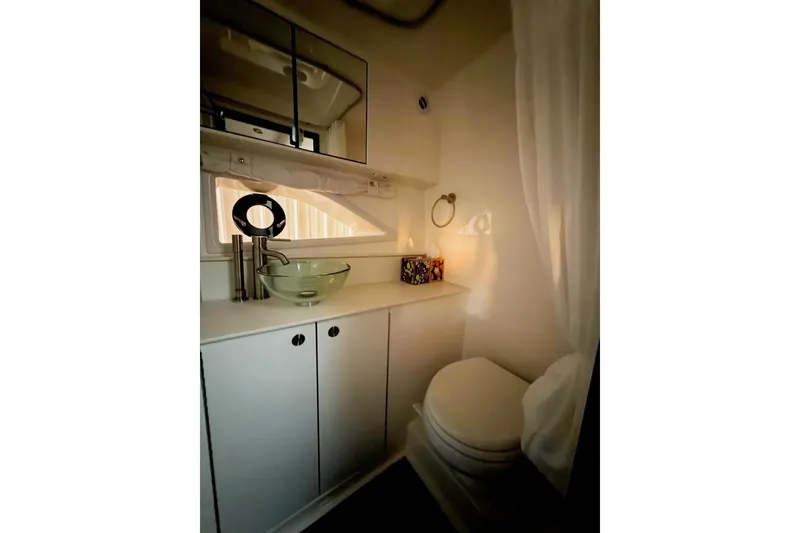 Slide: The Image of 2023 Sea Ray Sundancer 320 Coupe bathroom with modern sink and mirror. - 20