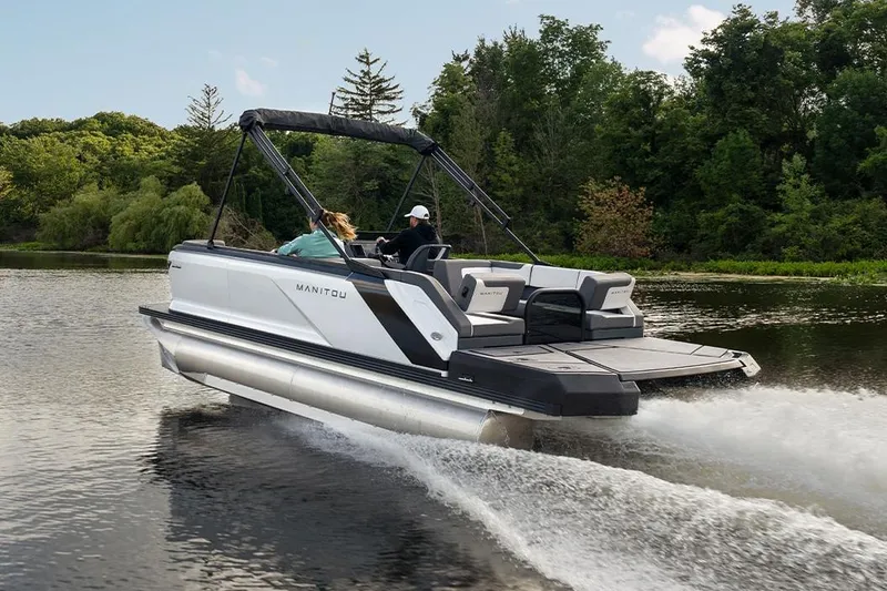 Slide: The Image of Manufacturer Provided Image: 2025 Manitou Cruise pontoon boat on a serene river. - 2