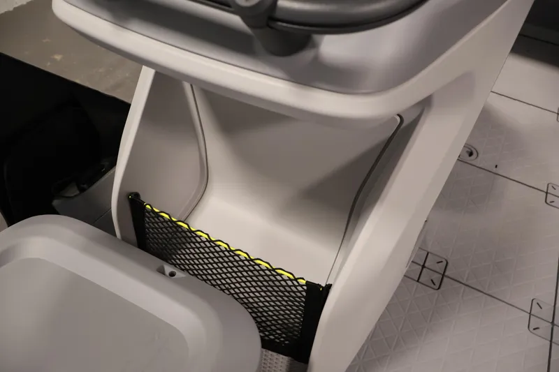 Slide: The Image of 2026 Sea-Doo Switch Fish 18 interior storage compartment with netting and textured flooring. - 30