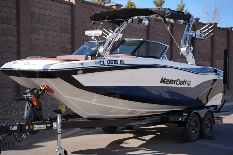 Slide: The Image of 2019 MasterCraft XT22 boat on trailer, sleek design, parked outdoors. - 15