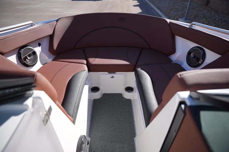 Slide: The Image of 2019 MasterCraft XT22 boat interior with brown seating and built-in speakers. - 16