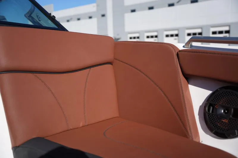 Slide: The Image of 2019 MasterCraft XT22 boat interior with brown leather seating and speaker detail. - 17