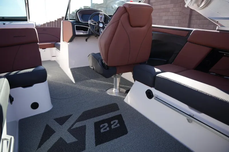 Slide: The Image of 2019 MasterCraft XT22 boat interior with brown seating and steering wheel. - 22