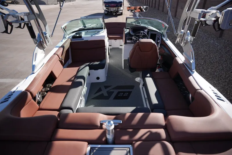Slide: The Image of 2019 MasterCraft XT22 boat interior with brown seating and modern dashboard. - 25