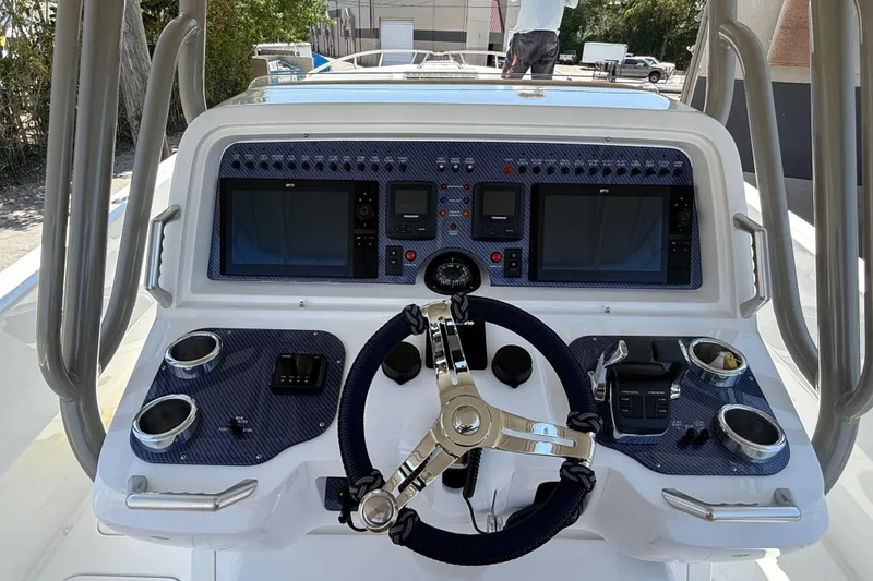 Slide: The Image of Control panel of a 2008 Don Smith 45 boat with steering wheel and navigation screens. - 10