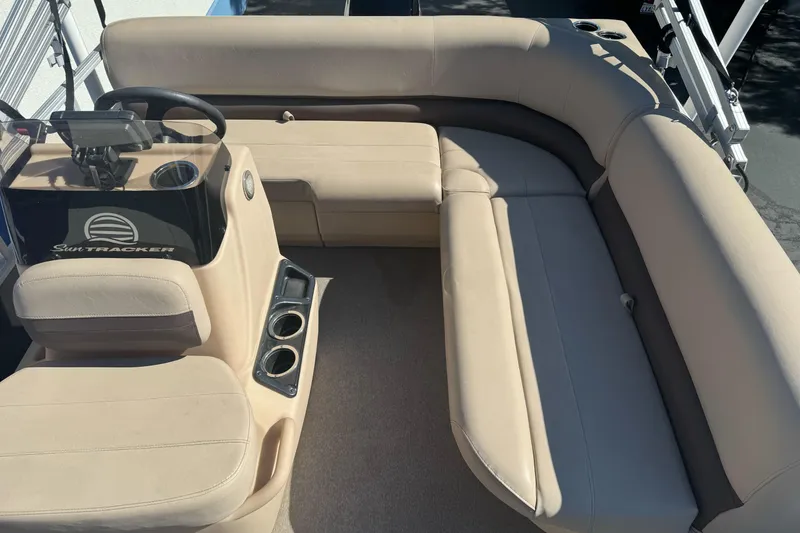 Slide: The Image of 2019 Sun Tracker Bass Buggy 16 DLX interior with beige seating and steering console. - 12