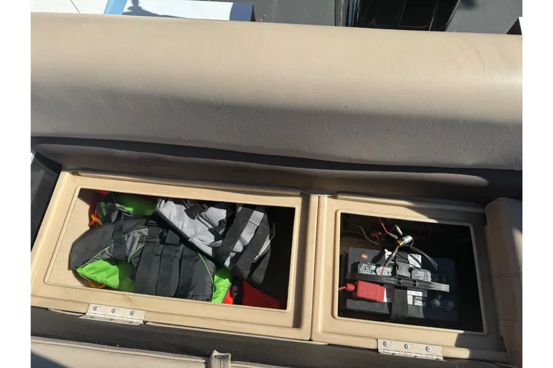 Slide: The Image of Storage compartments on a 2019 Sun Tracker Bass Buggy 16 DLX, containing life jackets and a battery. - 14