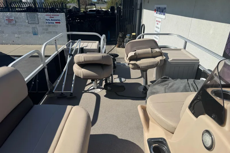 Slide: The Image of 2019 Sun Tracker Bass Buggy 16 DLX pontoon boat interior with beige seating and railing. - 19