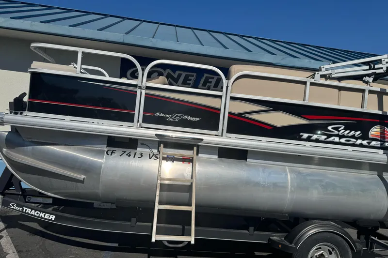 Slide: The Image of 2019 Sun Tracker Bass Buggy 16 DLX pontoon boat on trailer, side view. - 2