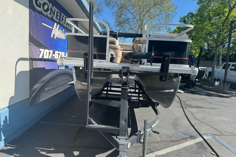 Slide: The Image of 2019 Sun Tracker Bass Buggy 16 DLX pontoon boat on trailer, parked outdoors. - 5