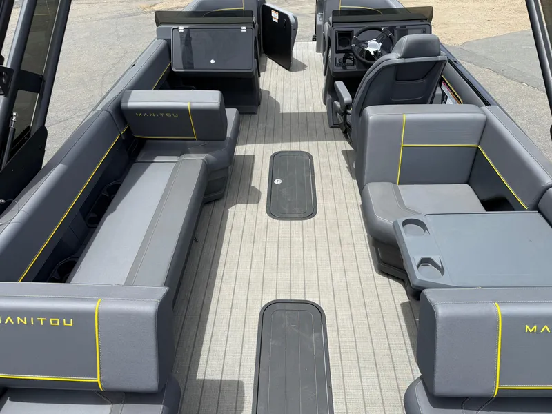 Slide: The Image of 2025 Manitou Explore boat interior with gray seating and yellow accents. - 3