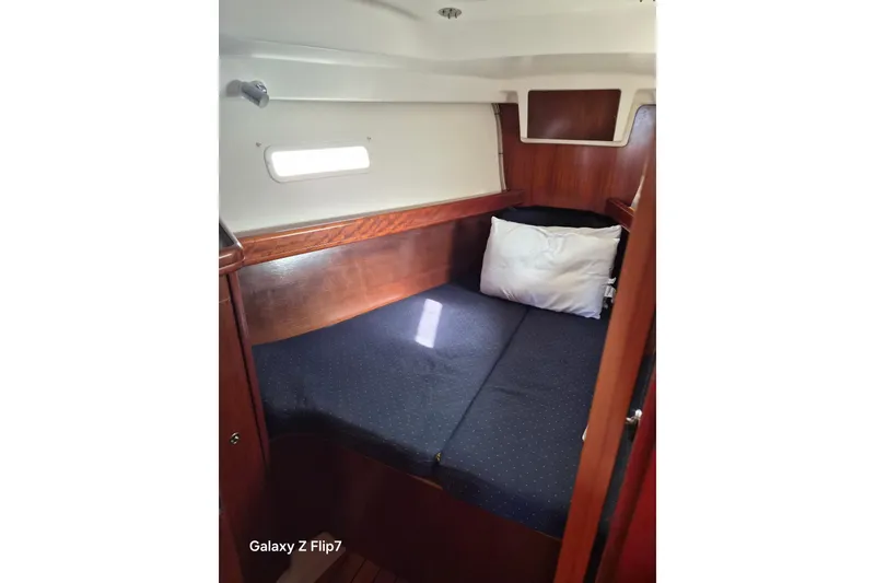 Slide: The Image of Cozy cabin interior of 2005 Beneteau Oceanis Clipper 373 sailboat with bed and pillow. - 10