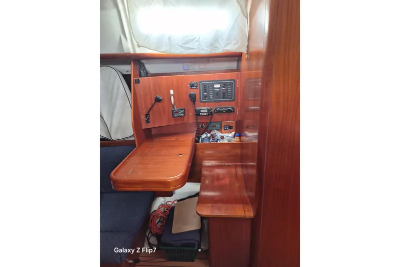Slide: The Image of Navigation station inside a 2005 Beneteau Oceanis Clipper 373 sailboat, featuring wooden cabinetry. - 11