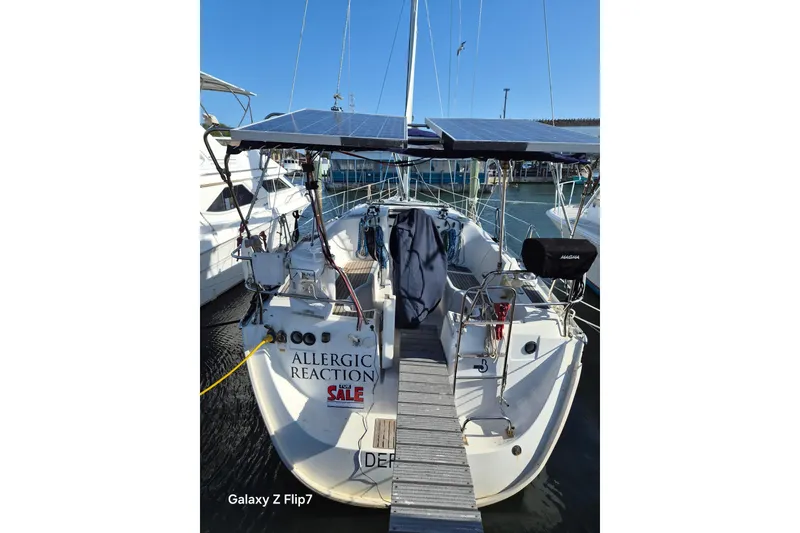 Slide: The Image of 2005 Beneteau Oceanis Clipper 373 sailboat docked, featuring solar panels and "For Sale" sign. - 2
