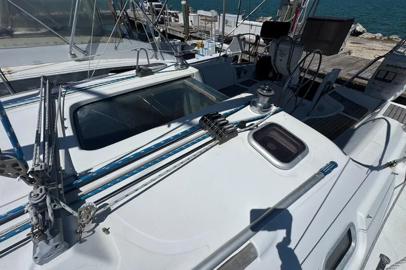Slide: The Image of 2005 Beneteau Oceanis Clipper 373 sailboat deck with rigging and winch, docked by the sea. - 23