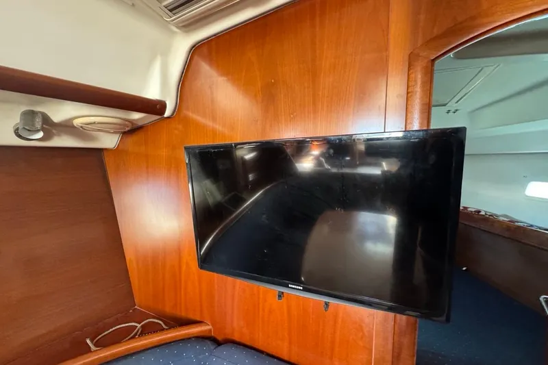 Slide: The Image of Flat-screen TV mounted on wooden interior of 2005 Beneteau Oceanis Clipper 373 yacht. - 35