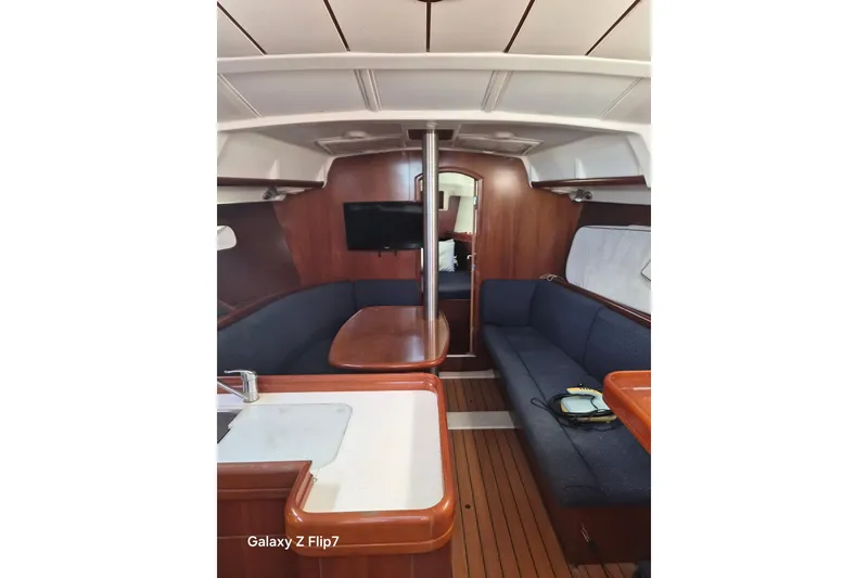 Slide: The Image of Interior of 2005 Beneteau Oceanis Clipper 373 yacht with wooden finish and blue seating. - 8