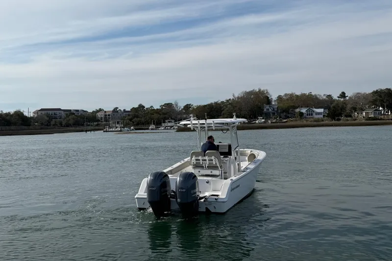 Slide: The Image of 2021 Sportsman Heritage 251 Center Console boat on calm water near shoreline. - 16