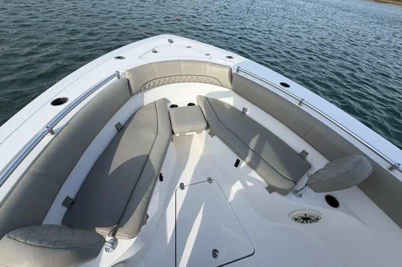 Slide: The Image of 2021 Sportsman Heritage 251 Center Console boat interior with cushioned seating on calm water. - 26