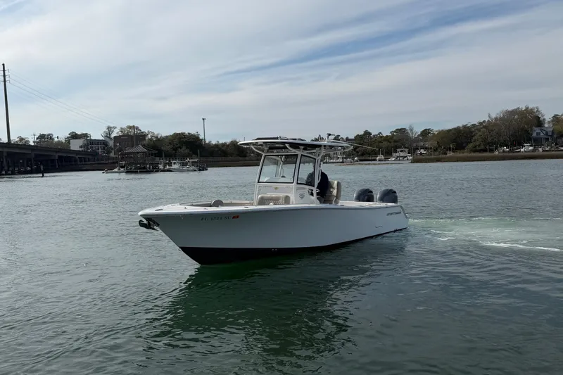 Slide: The Image of 2021 Sportsman Heritage 251 Center Console boat cruising on a calm river. - 3