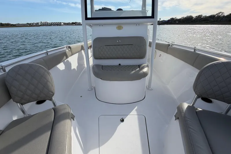 Slide: The Image of 2021 Sportsman Heritage 251 Center Console boat interior with cushioned seating on calm water. - 32