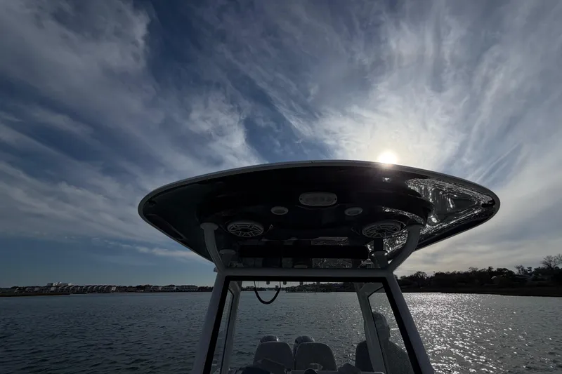 Slide: The Image of 2021 Sportsman Heritage 251 Center Console boat under a dramatic sky with sun. - 36