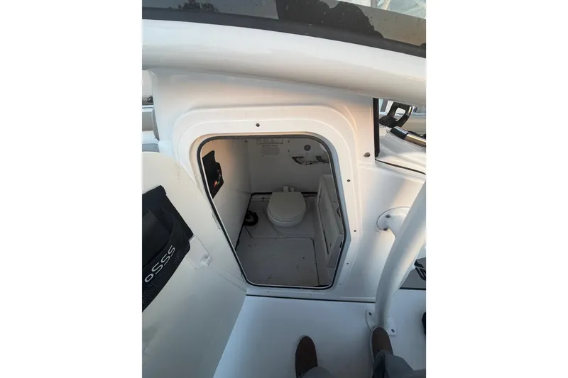 Slide: The Image of 2021 Sportsman Heritage 251 Center Console boat interior with compact marine toilet. - 59