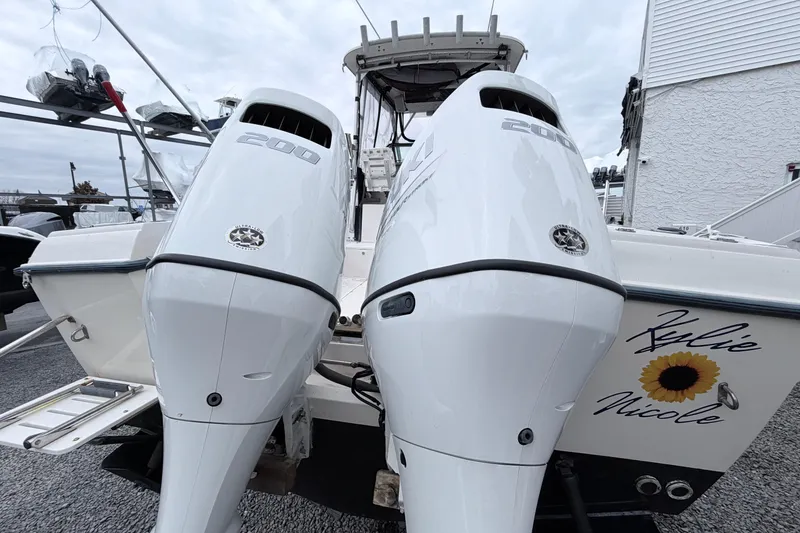 Slide: The Image of 1990 Grady-White Sailfish 25 Sportbridge with twin 200 horsepower engines, docked outdoors. - 3