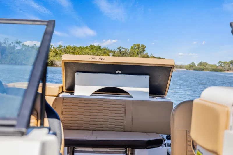 Slide: The Image of 2024 Sea Ray SPX 230 Outboard boat interior with open storage compartment, scenic water view. - 14
