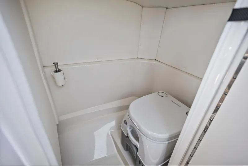 Slide: The Image of 2024 Sea Ray SPX 230 Outboard boat interior with compact marine toilet. - 16