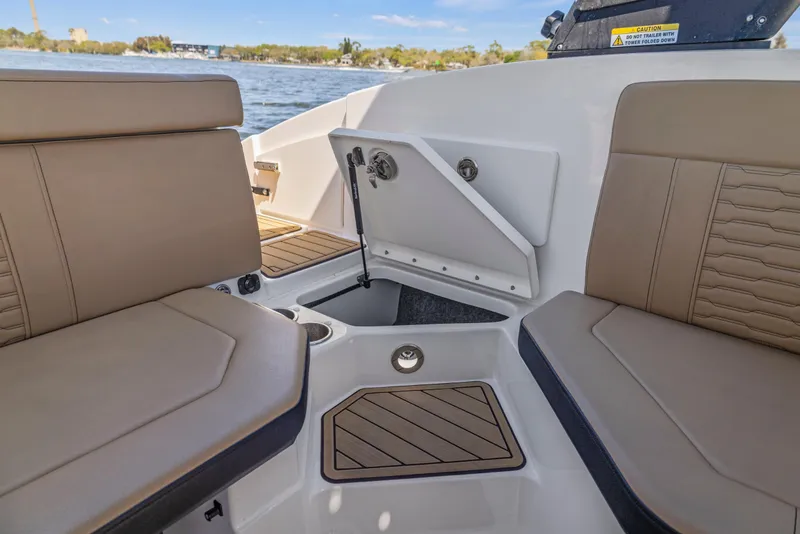 Slide: The Image of 2024 Sea Ray SPX 230 Outboard interior with tan seating and storage compartment. - 20
