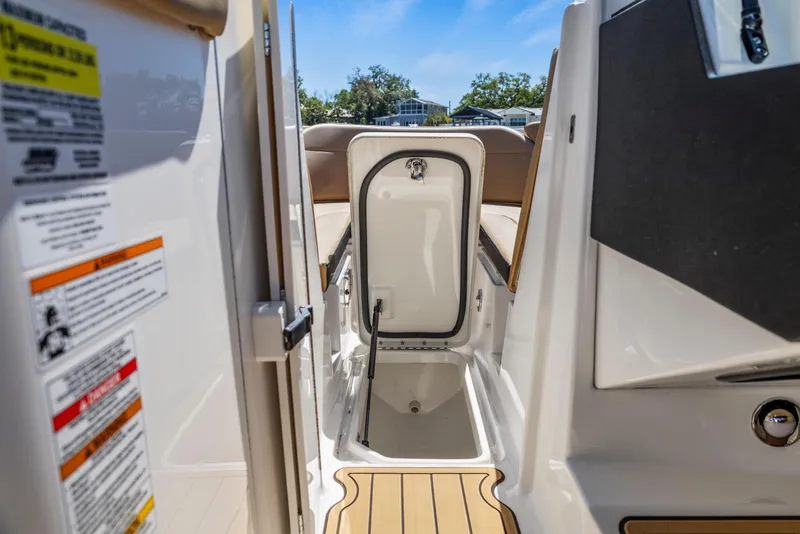 Slide: The Image of 2024 Sea Ray SPX 230 Outboard boat storage compartment with open hatch. - 26