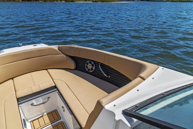 Slide: The Image of 2024 Sea Ray SPX 230 Outboard boat interior with tan seating on blue water. - 32