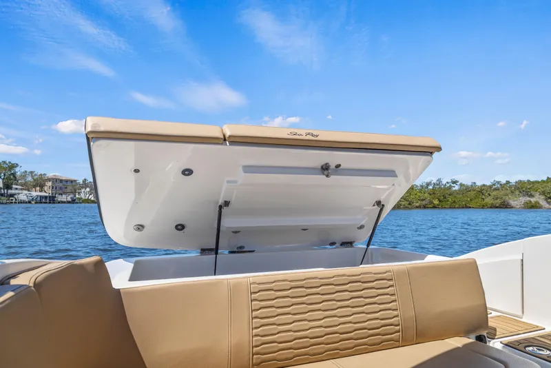 Slide: The Image of 2024 Sea Ray SPX 230 Outboard boat with open storage compartment on a sunny day. - 35