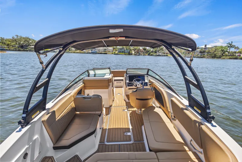 Slide: The Image of 2024 Sea Ray SPX 230 Outboard boat interior with seating and steering wheel on a sunny day. - 40