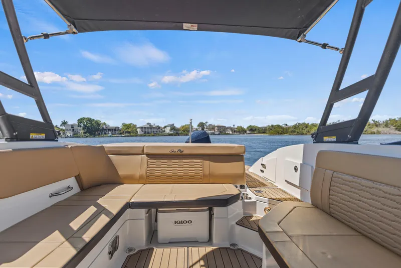 Slide: The Image of 2024 Sea Ray SPX 230 Outboard boat interior with tan seating and scenic water view. - 44