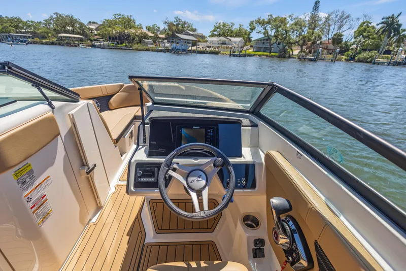 Slide: The Image of 2024 Sea Ray SPX 230 Outboard boat interior with steering wheel and dashboard on a sunny day. - 45