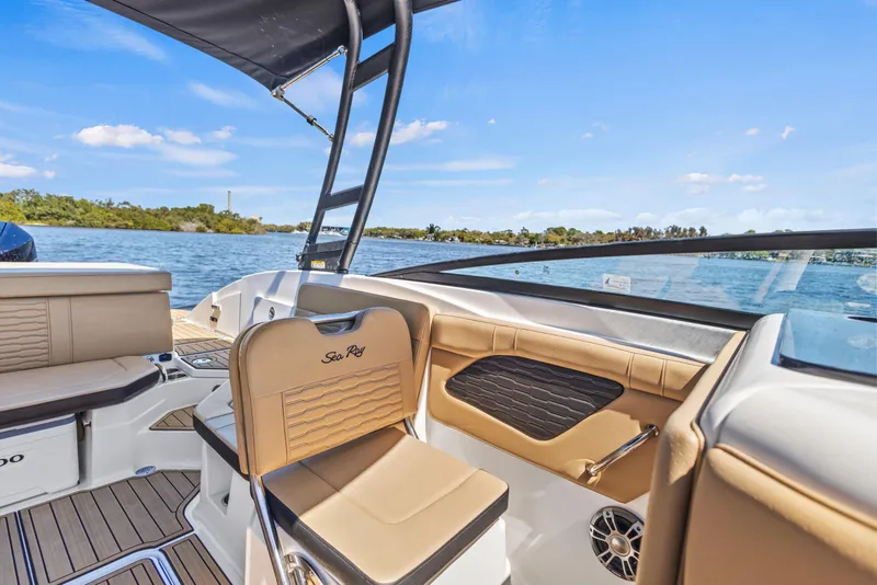 Slide: The Image of 2024 Sea Ray SPX 230 Outboard interior with tan seating, on a sunny lake. - 47