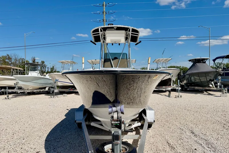 Slide: The Image of 2003 Contender 21 Open boat on trailer, displayed in a boatyard under clear blue sky. - 2