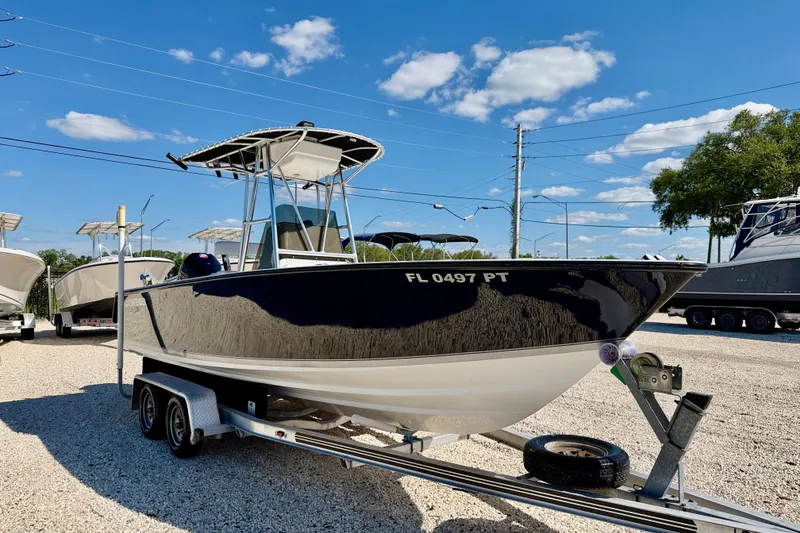 Slide: The Image of 2003 Contender 21 Open boat on trailer under clear blue sky. - 3