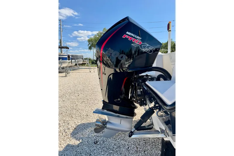 Slide: The Image of Mercury Pro XS outboard motor on 2003 Contender 21 Open boat, parked on gravel. - 32