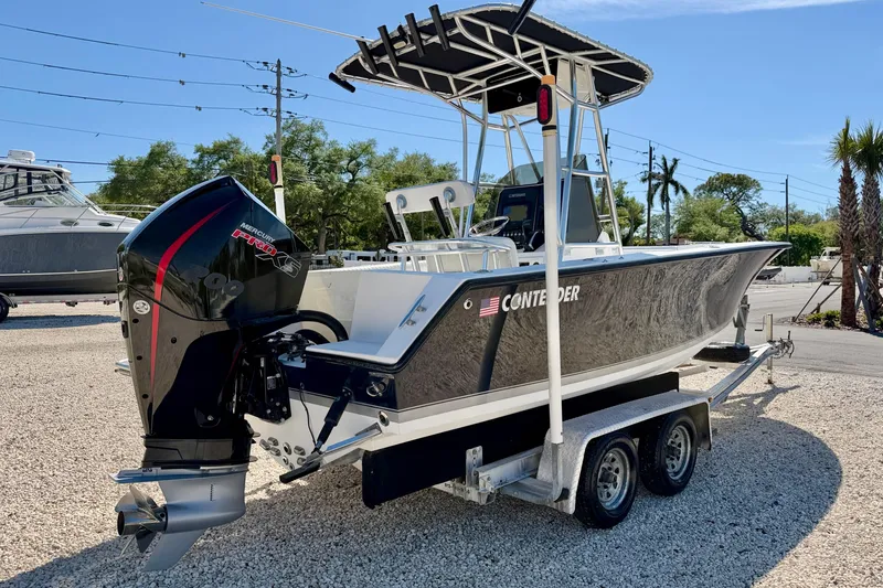 Slide: The Image of 2003 Contender 21 Open boat on trailer with Mercury engine, parked outdoors. - 4