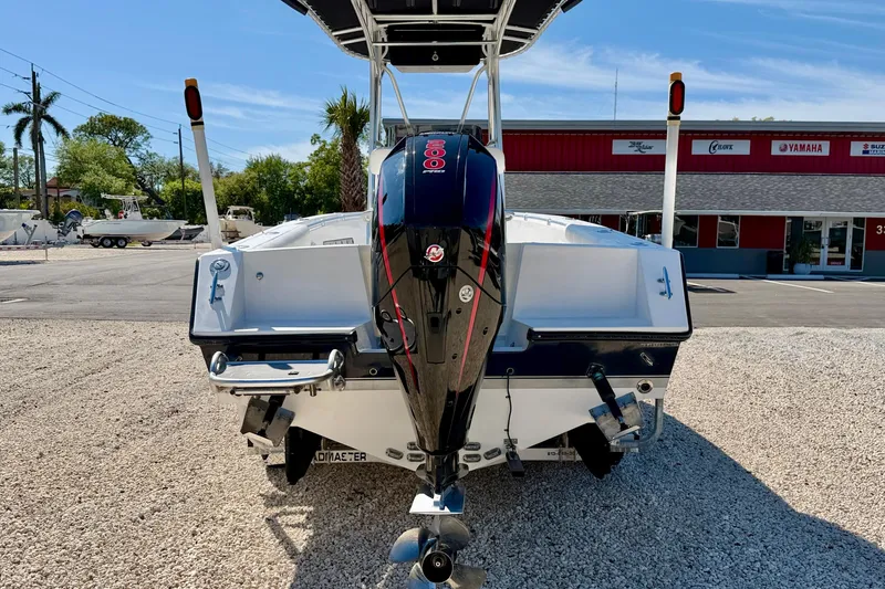 Slide: The Image of 2003 Contender 21 Open boat with powerful outboard motor, parked on gravel lot. - 5