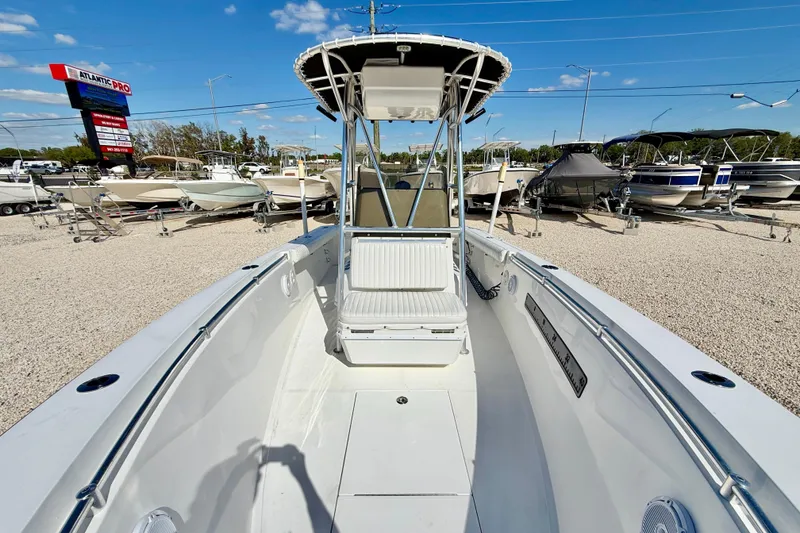 Slide: The Image of 2003 Contender 21 Open boat displayed at a dealership under a clear blue sky. - 8