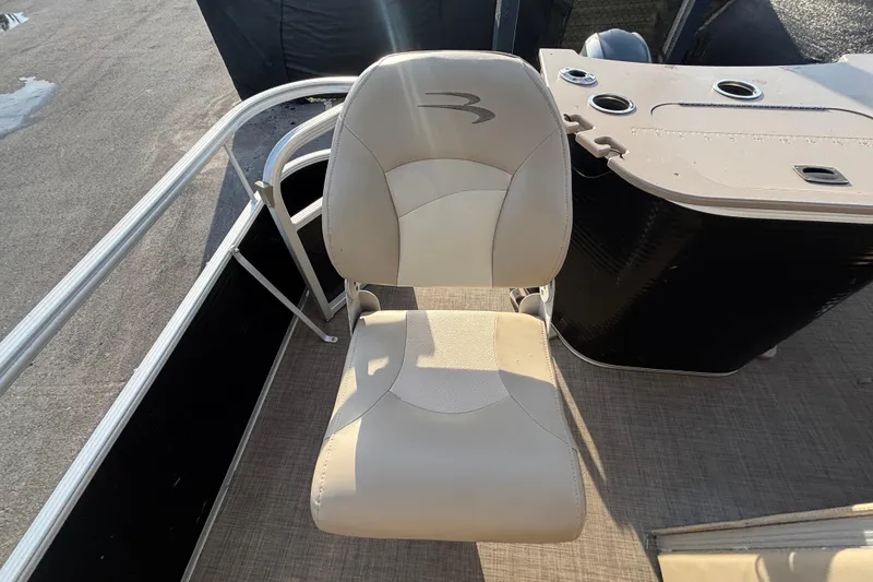 Slide: The Image of 2015 Bennington 20 SSX boat seat with beige upholstery and console in sunlight. - 22