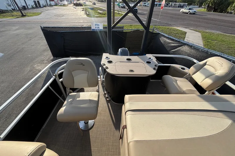 Slide: The Image of 2015 Bennington 20 SSX pontoon boat interior with beige seating and control console. - 23