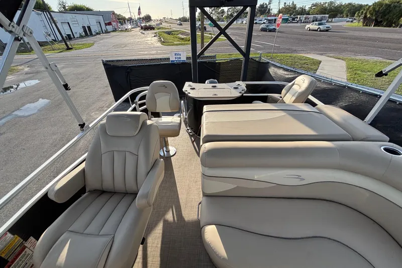 Slide: The Image of 2015 Bennington 20 SSX pontoon boat interior with beige seating and table. - 24