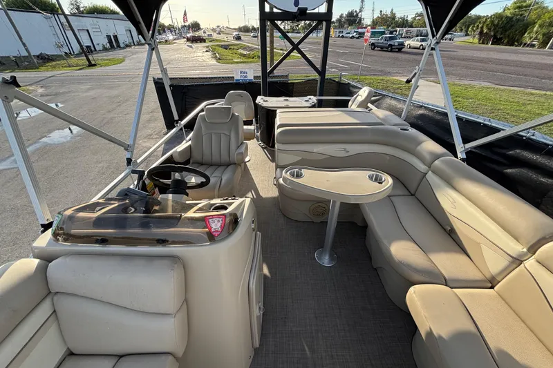 Slide: The Image of 2015 Bennington 20 SSX pontoon boat interior with beige seating and steering console. - 25